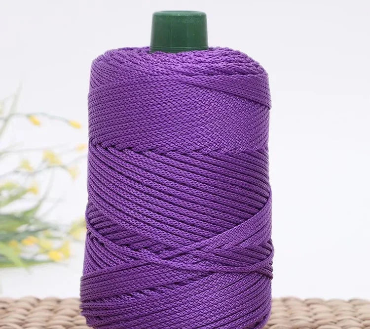 Purple crochet ice rope in a spool with a green cap resting on a woven mat.