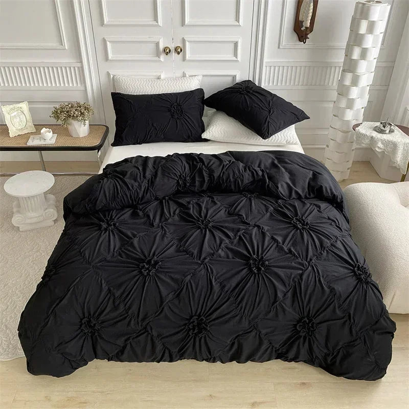 A black duvet cover set with a quilted pattern displayed on a bed with white bedding and decorative wall paneling.