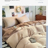 A close-up of a beige four-piece washed bed set featuring soft linens and pillows on a bed.