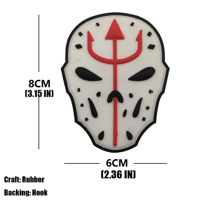 A black and white silicone patch shaped like a skull with a red trident symbol.
