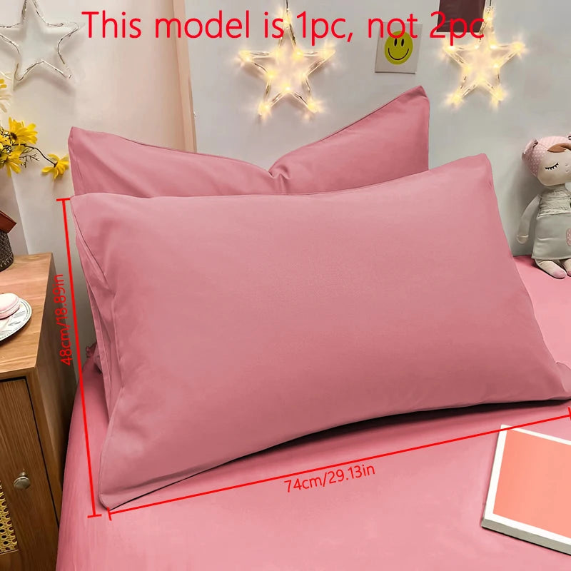 A pink matte solid color pillowcase is shown on a bed with decorative star light fixtures.