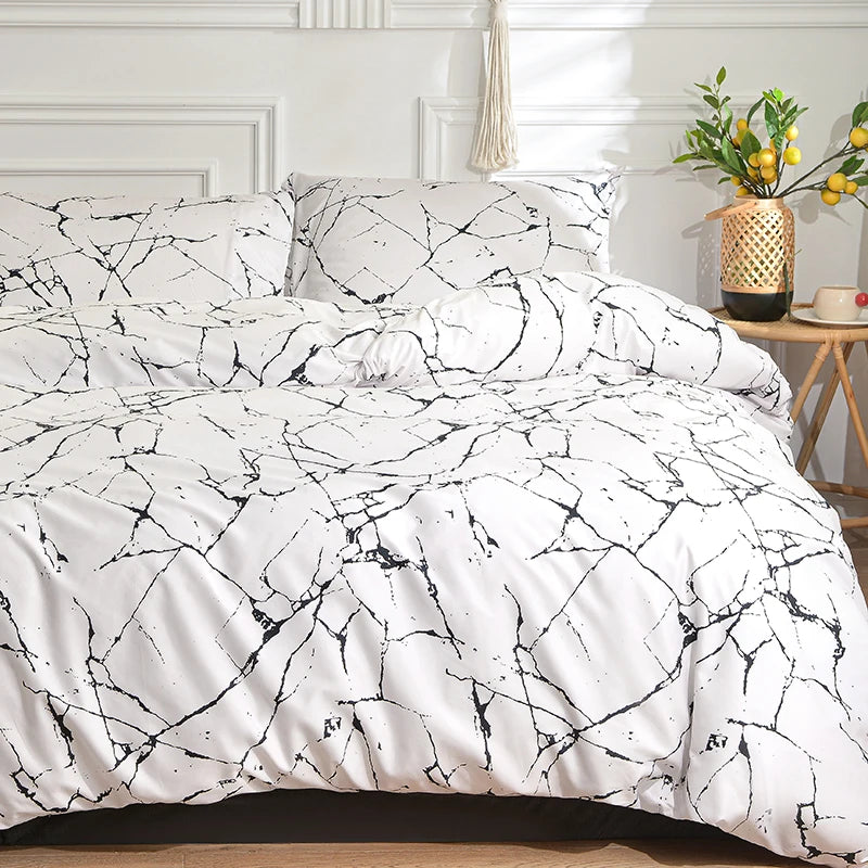 White duvet cover set with marble print pattern and matching pillowcases on a bed.