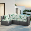 A gray outdoor sofa featuring light green floral patterned cushions set on a patio near a pool and white modern architecture.