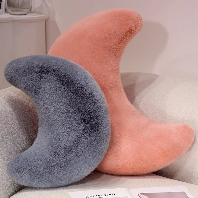 A pair of fuzzy throw pillows in soft peach and gray colors resting on a light-colored sofa.