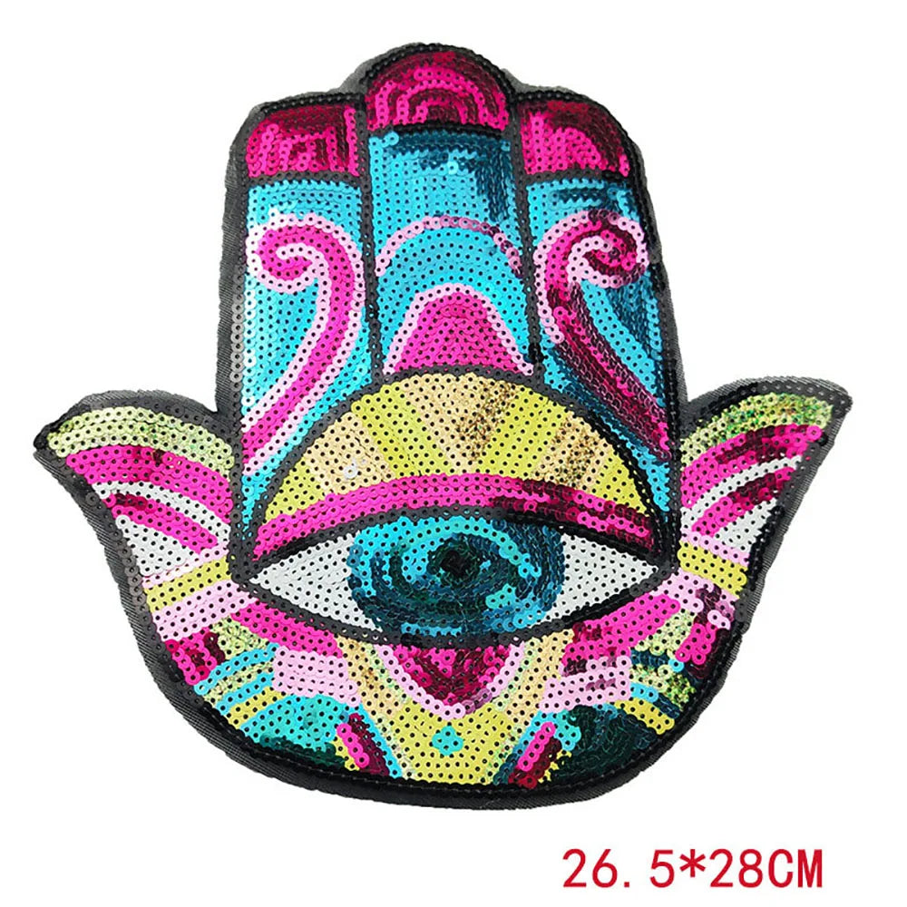 A colorful iron-on patch featuring a stylized blue eye design made with sequins and vibrant colors.