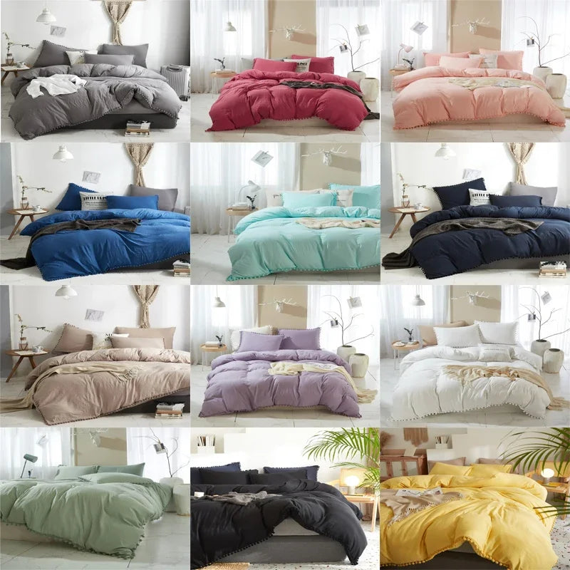 A collection of soft washed duvet covers in various shades including pink, purple, blue, and yellow with pom-pom decorations.