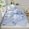 Light blue quilted quilt set with matching pillows and a blanket displayed on a white bed.