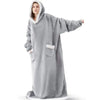 A person wearing a gray oversized flannel blanket pyjama set with a hood.