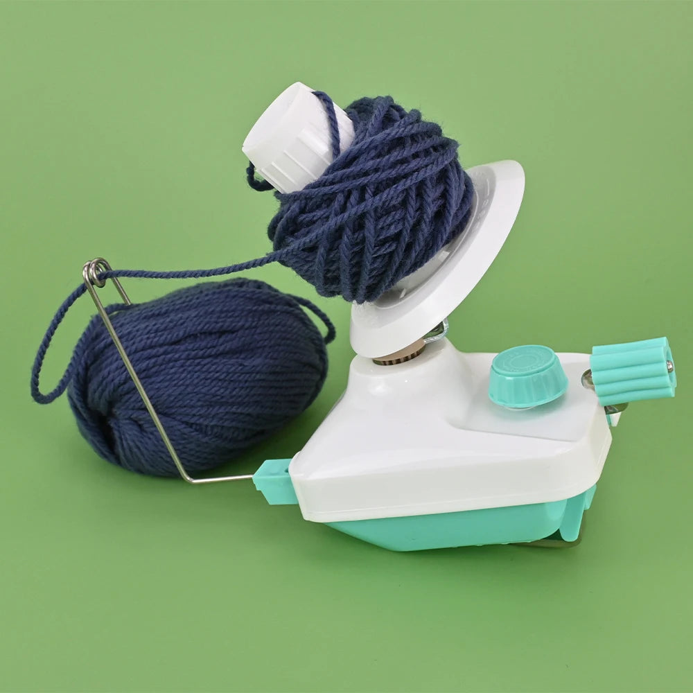 A white hand-operated wool yarn winder device with a blue yarn ball and spindle.