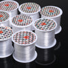 Rolls of precision nylon beading thread for jewelry making stacked on a dark surface