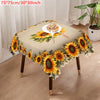 A beige tablecloth decorated with a sunflower floral pattern, featuring a small plate of bread.