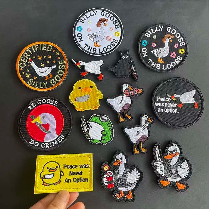 A collection of embroidered patches featuring various animal designs like geese and ducks on a dark gray background.