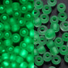 A close-up view of a large pack of bright green glow-in-the-dark glass seed beads.