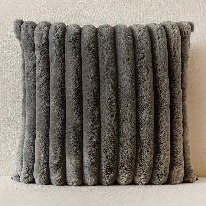 A stack of gray faux fur stripe corduroy pillow covers standing vertically.