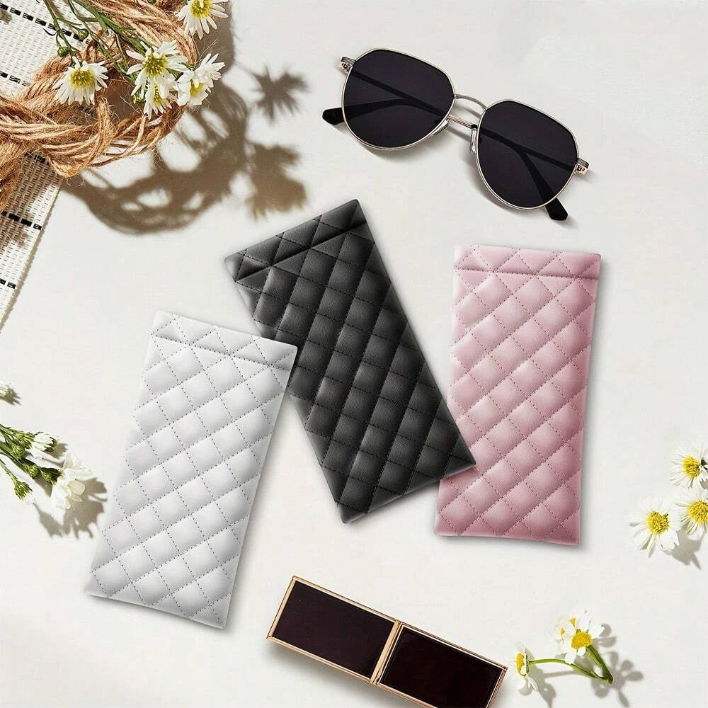 A collection of quilted PU leather eyeglass cases in black, gray, and pink, along with a pair of sunglasses and a cleaning cl