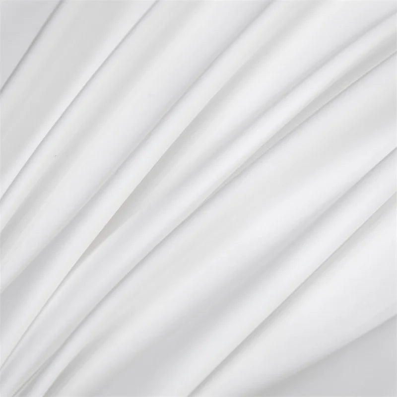 Soft white luxury bamboo flat sheets draped in flowing fabric.