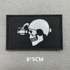 A black embroidered patch featuring a white skull with a scope and a crosshairs design.