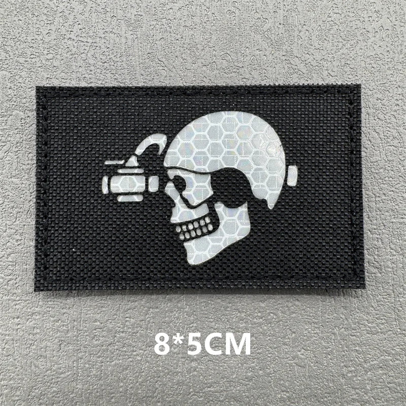 A black embroidered patch featuring a white skull with a scope and a crosshairs design.