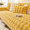 A bright yellow plush velvet sofa cover with a textured, fluffy appearance is displayed on a bed.