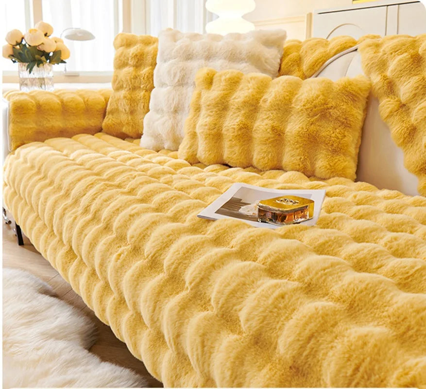 A bright yellow plush velvet sofa cover with a textured, fluffy appearance is displayed on a bed.