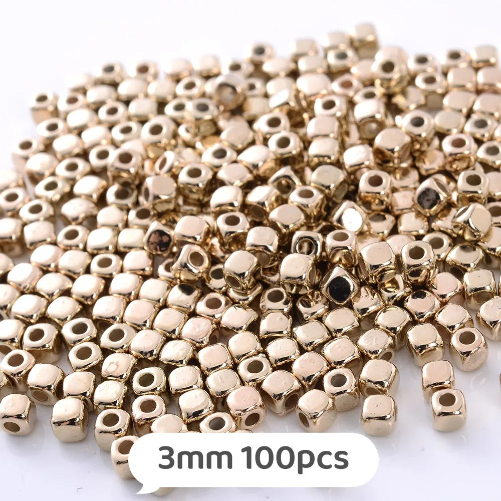 A pile of small gold-colored geometric acrylic beads for jewelry making