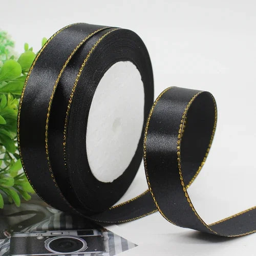 Roll of black satin ribbon with gold edge for gift wrapping and crafts