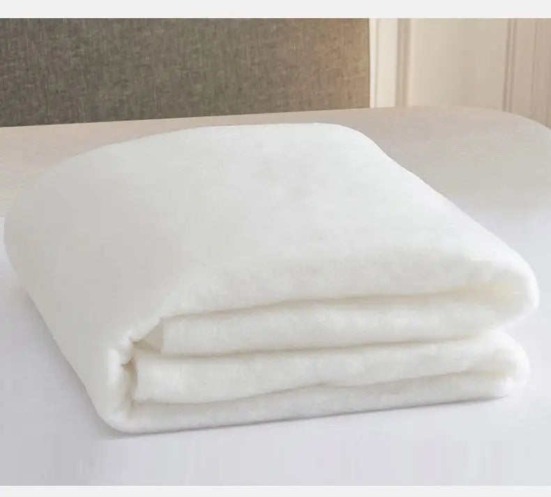 White soft breathable quilt folded neatly on a white surface.