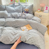 A light gray microfiber duvet cover set with matching pillowcases and a teddy bear on a bed.