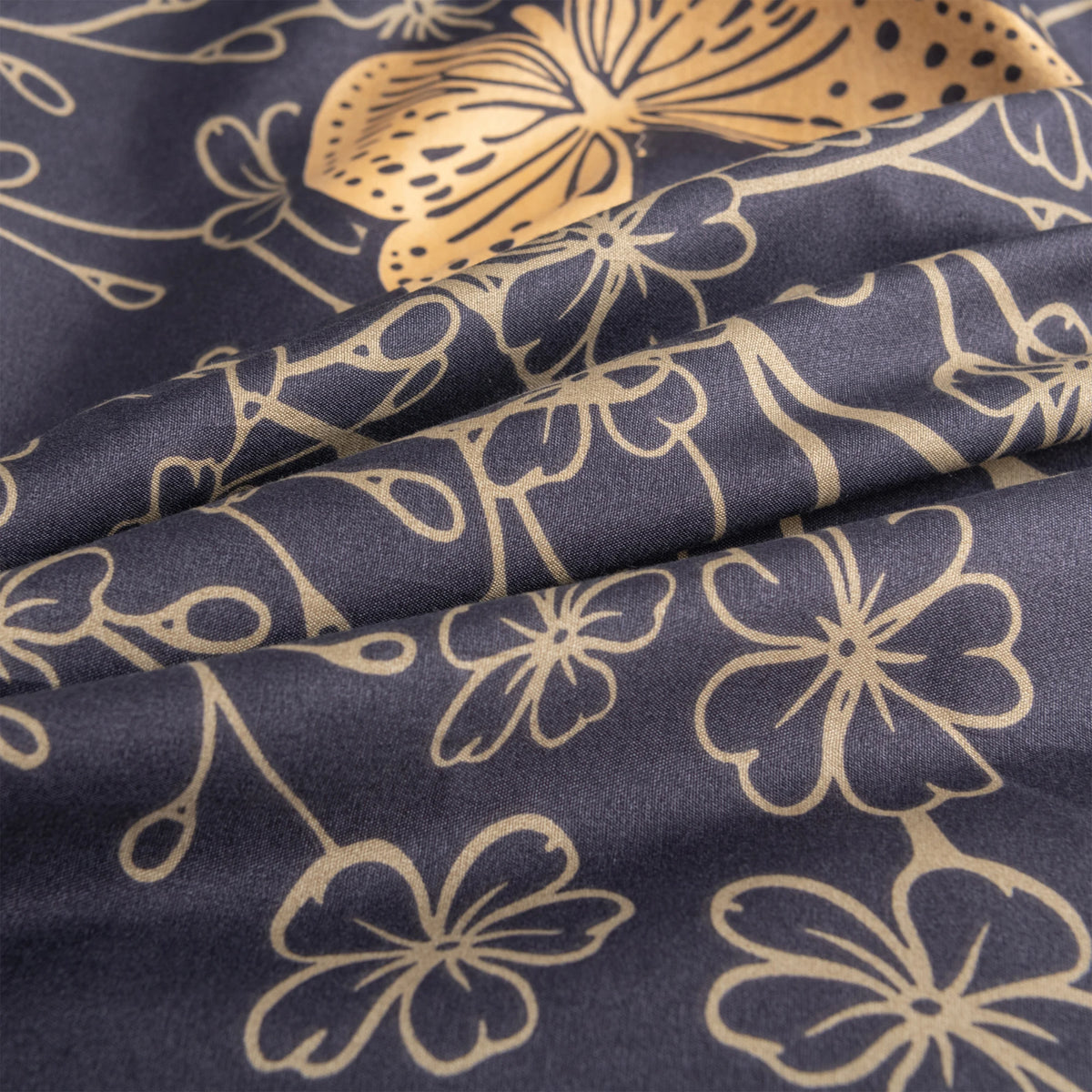 Dark blue fabric with a gold butterfly and floral print, showing the texture and drape of the material.