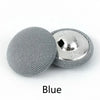 A round, gray fabric-covered shank button with a silver backing is shown.