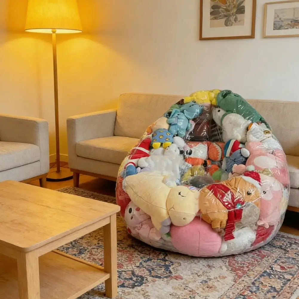 A large, colorful inflatable storage bag filled with various plush toys sits on a rug next to a wooden table.