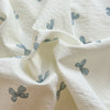White microfiber duvet fabric with light blue floral print folded and draped.