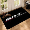 Black door mat featuring white text SRT MOTORSPORTS and a red stripe on a light wood floor.