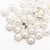 A cluster of clear and ivory pearl rhinestone sew-on buttons arranged in a floral pattern.
