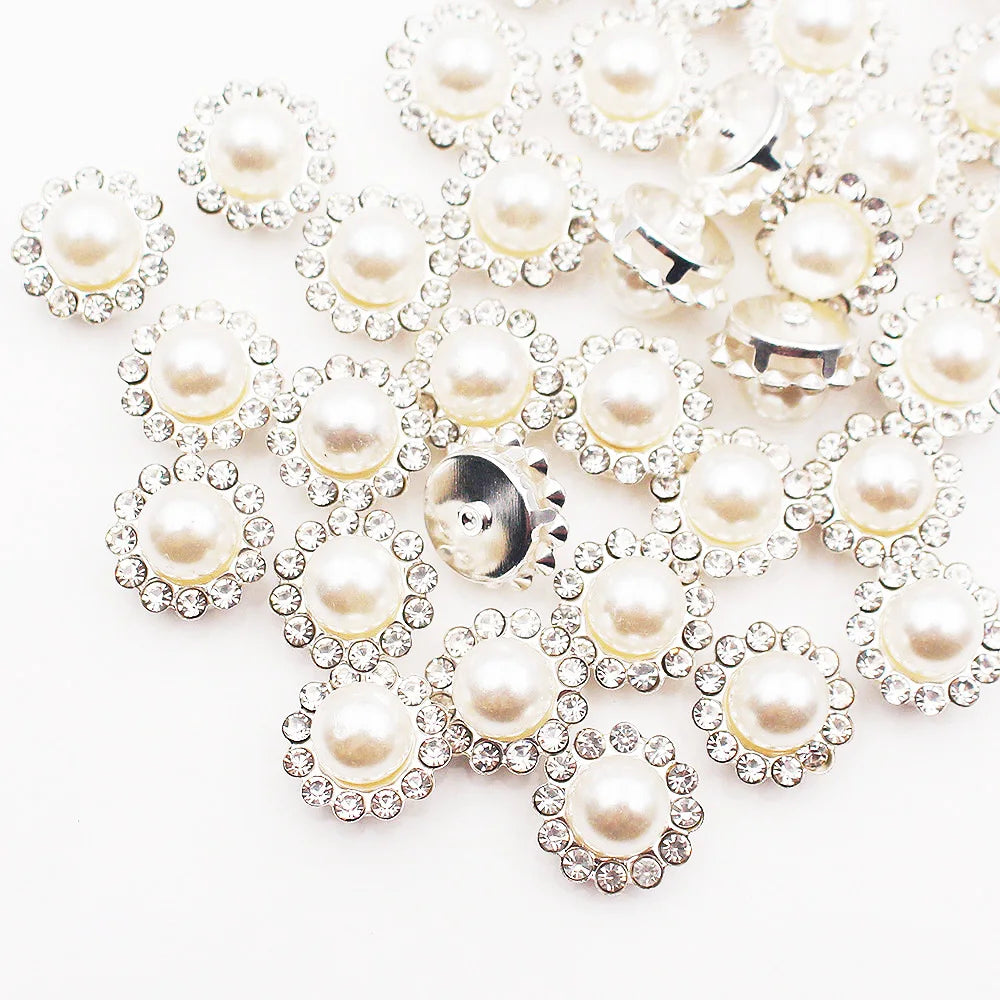 A cluster of clear and ivory pearl rhinestone sew-on buttons arranged in a floral pattern.