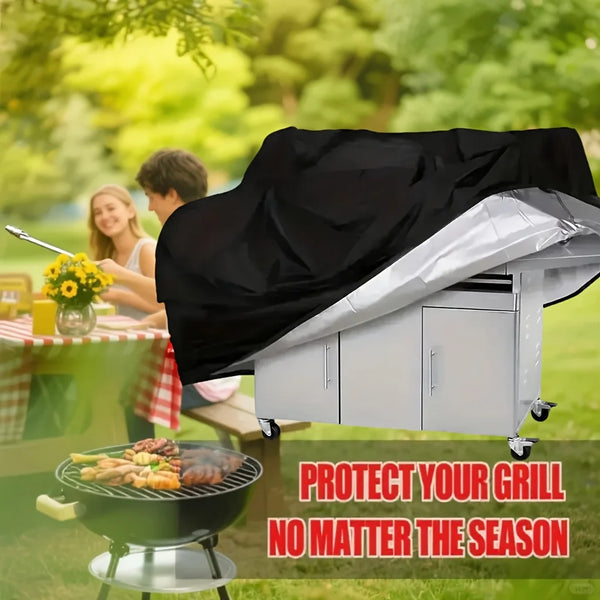 A silver heavy-duty grill cover is shown protecting a charcoal grill outdoors in a sunny park setting.