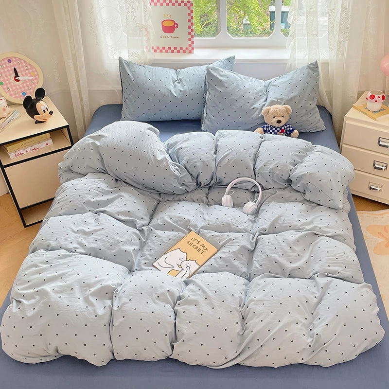 A light blue microfiber duvet cover set with matching pillowcases and a teddy bear toy on a bed.