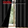 Solid black blackout curtains hanging in a doorway, showing a view of greenery outside.