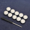 A silver metal snap button tool with multiple round buttons resting on a dark blue fabric.