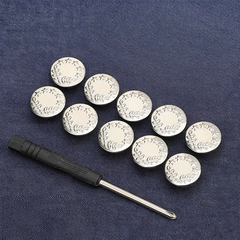 A silver metal snap button tool with multiple round buttons resting on a dark blue fabric.
