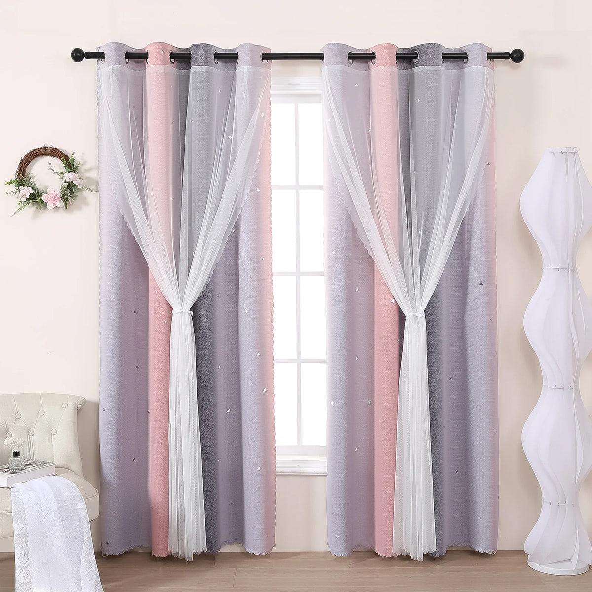 Grey and pink gradient star perforated curtains hanging on a rod in a window frame.