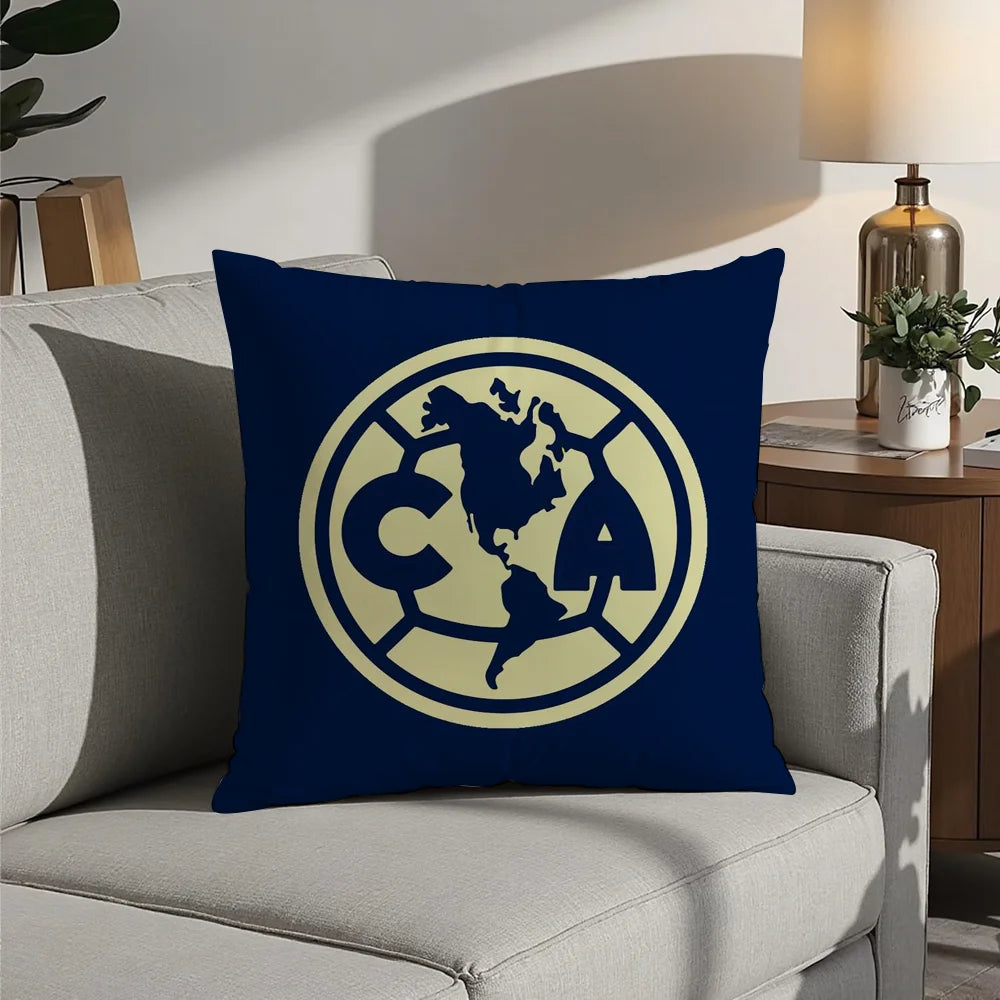 A navy blue decorative pillow featuring a gold-colored circular logo with the letters CA and a map outline of North America.