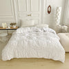 White quilted duvet cover set displayed on a bed with white molding and pillows.