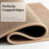 A close-up of a beige non-slip faux sisal kitchen rug with perfectly cropped edges rolled up.