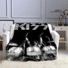 A black printed flannel travel blanket featuring a silhouette of a drummer playing a drum kit.