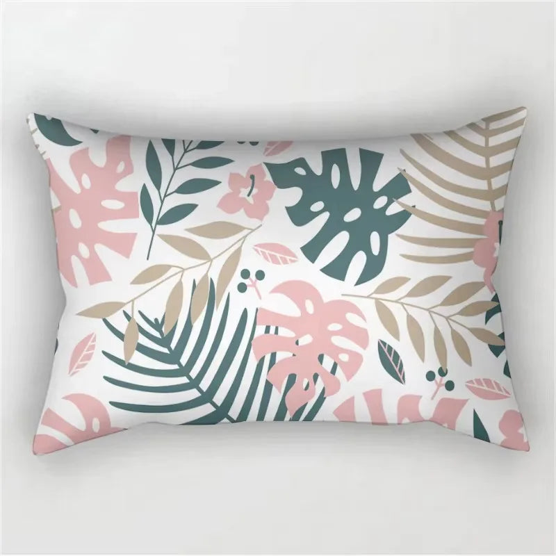 A decorative pillowcase featuring a tropical leaf print in shades of pink, green, and beige.