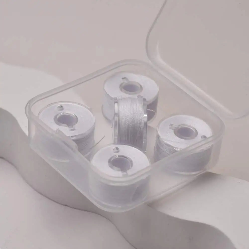 Clear plastic container holding several spools of prewound sewing machine bobbin threads