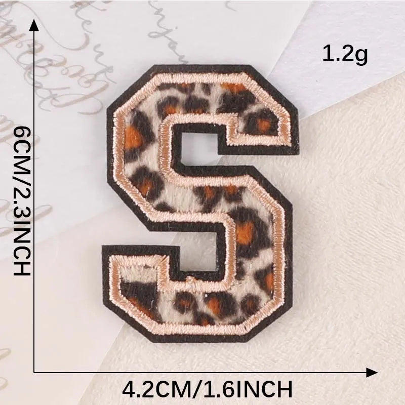A leopard print iron-on patch shaped like the letter S, measuring 4.2cm high and 1.2g.