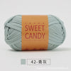 A ball of light mint green hand-dyed fabric strip yarn labeled Sweet Candy with Chinese characters.