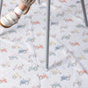 A white baby play mat with a repeating pattern of small orange and blue toy vehicles.